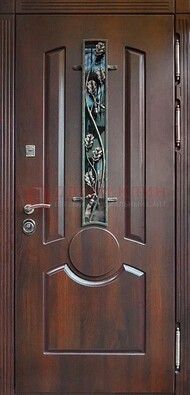Темная железная дверь со стеклом и ковкой для кирпичного дома ДСК-136 в Гатчине